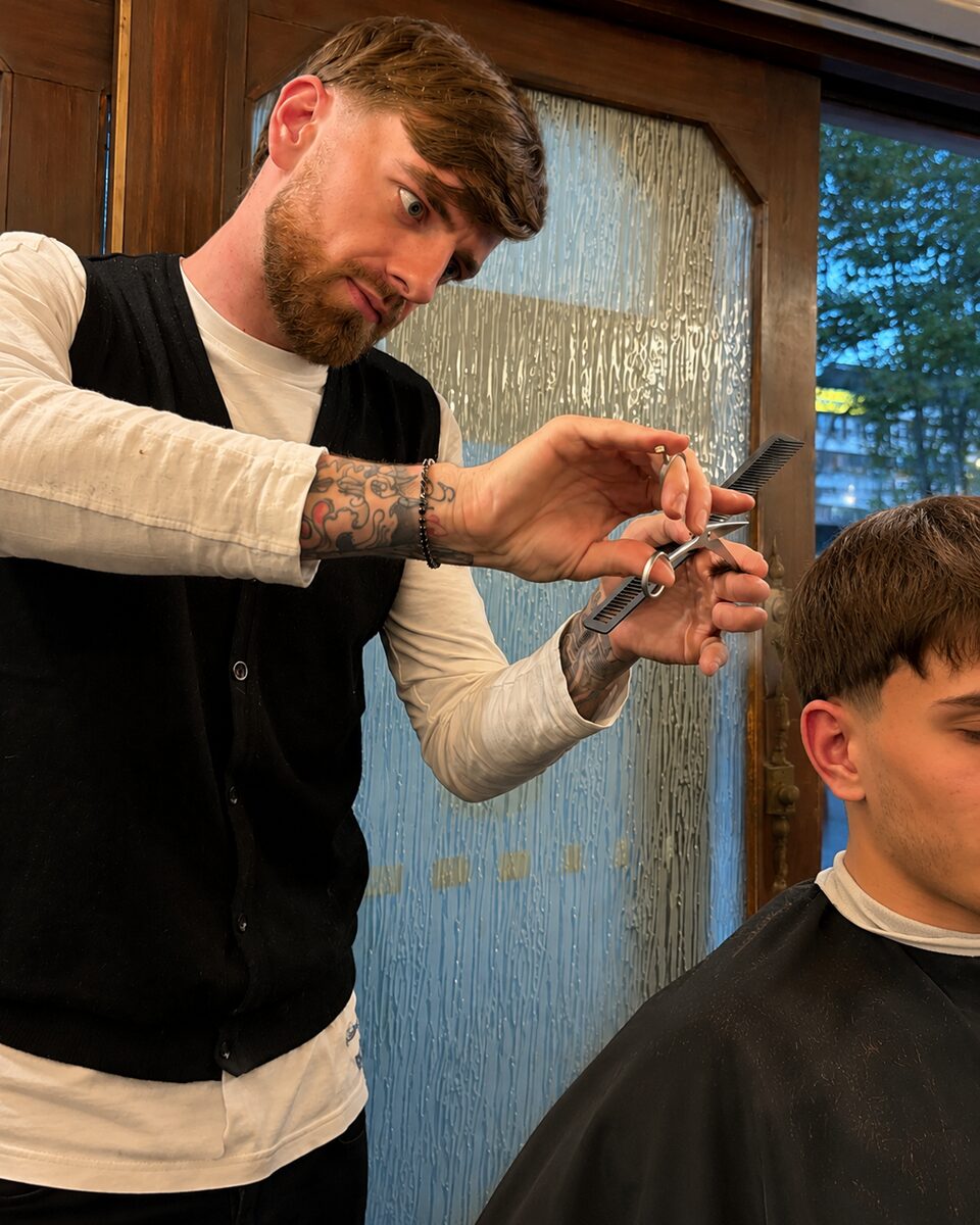 Mattia di Robert Barber Shop al lavoro